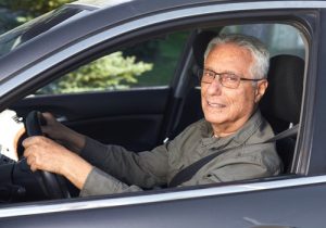 Senior citizen driving car with seatbelt on