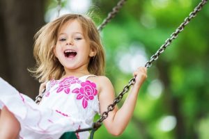 close up of little girl on a playground swing