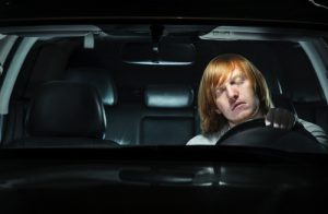 young man asleep behind the wheel. drowsy driving concept