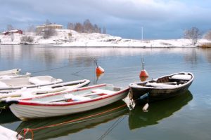 boats on a cold lake with snow in the background