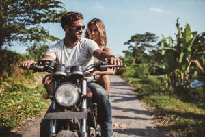 man riding motorcycle with woman