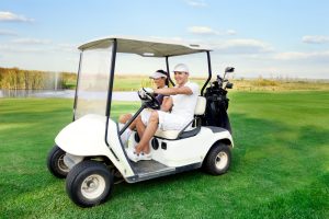 couple in a golf cart on a golf course