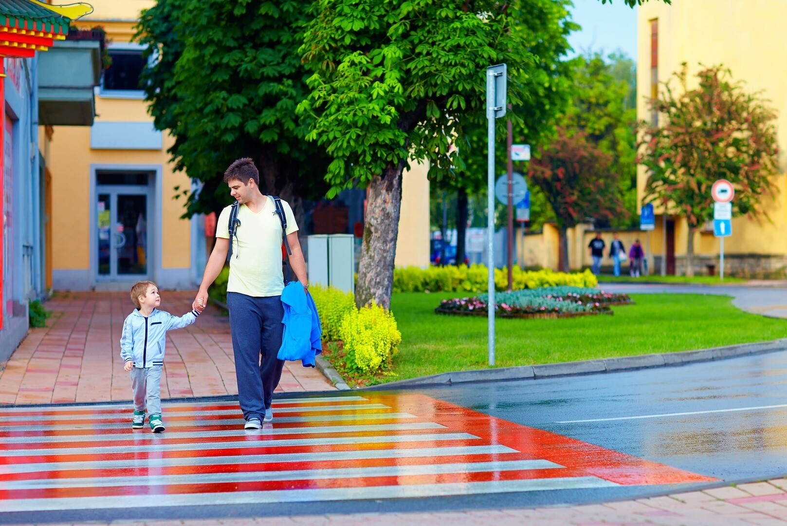 father and son crossing the road