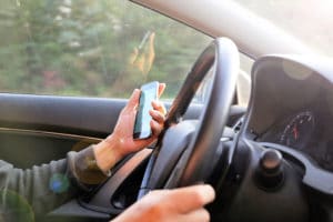 man using a cell phone while driving