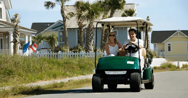 couple driving a golf cart in south carolina