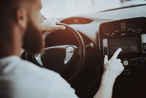 A rideshare driver checks his app during a ride.